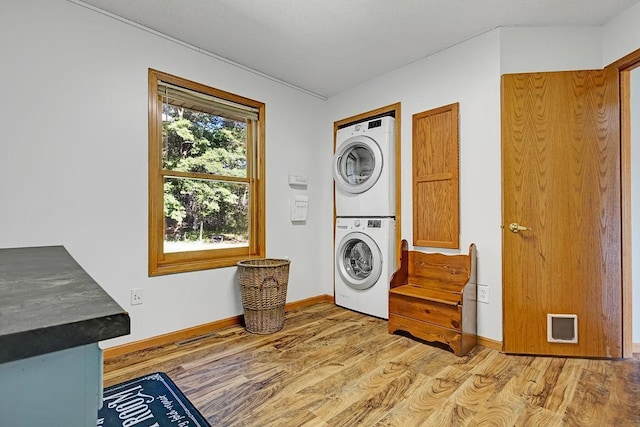 417 Whiskey Rd SW, Isanti, MN 55040 - laundry room featuring stacked washer / drying machine and light wood-style flooring