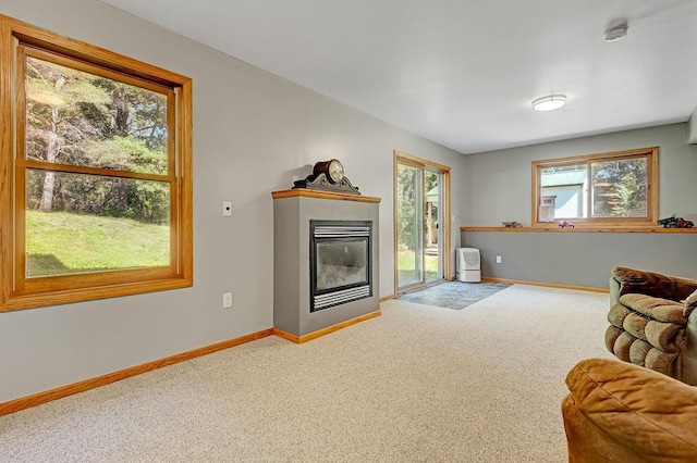 417 Whiskey Rd SW, Isanti, MN 55040 - carpeted living area with baseboards and a glass covered fireplace