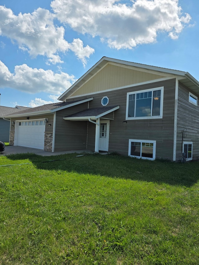 1719 Grand Ave, Worthington, MN 56187 - view of front facade with an attached garage, a front yard, and stone siding