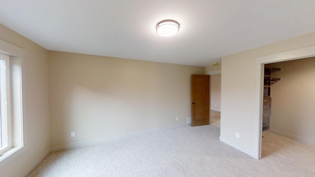 2329 9th St W, Albert Lea, MN 56007 - unfurnished bedroom featuring a walk in closet and light colored carpet