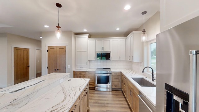 2329 9th St W, Albert Lea, MN 56007 - kitchen with stainless steel appliances, light stone counters, decorative backsplash, light wood finished floors, and recessed lighting