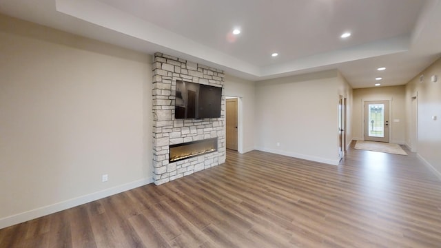 2329 9th St W, Albert Lea, MN 56007 - unfurnished living room with a raised ceiling, wood finished floors, a fireplace, and recessed lighting