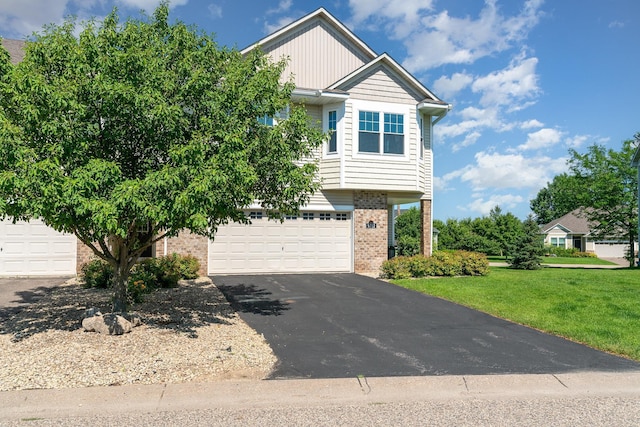 9742 Saint Andrews Dr, Elko New Market, MN 55020 - view of front of house with brick siding, asphalt driveway, an attached garage, and a front yard