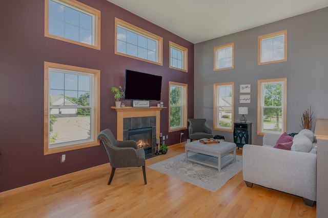 9742 Saint Andrews Dr, Elko New Market, MN 55020 - living area featuring a tiled fireplace, wood-type flooring, and a high ceiling