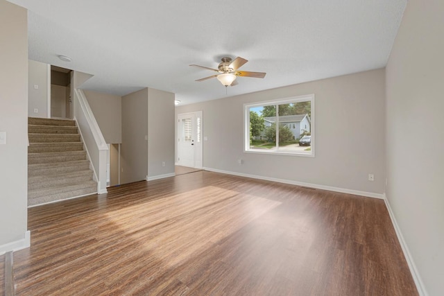 2112 York St, Saint Peter, MN 56082 - unfurnished living room featuring a ceiling fan, wood finished floors, and stairway