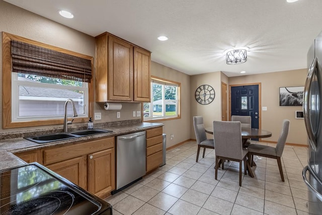 385 Lexington Ave, Le Center, MN 56057 - kitchen with appliances with stainless steel finishes, light tile patterned floors, brown cabinetry, recessed lighting, and dark countertops