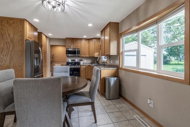 385 Lexington Ave, Le Center, MN 56057 - kitchen with stainless steel appliances, light tile patterned flooring, recessed lighting, light countertops, and brown cabinetry