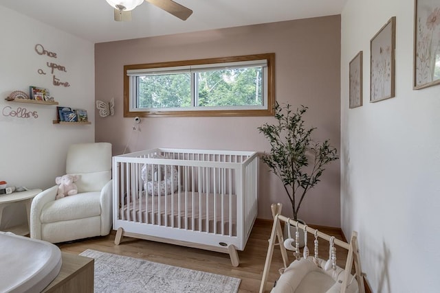 385 Lexington Ave, Le Center, MN 56057 - bedroom with a crib, wood finished floors, and a ceiling fan