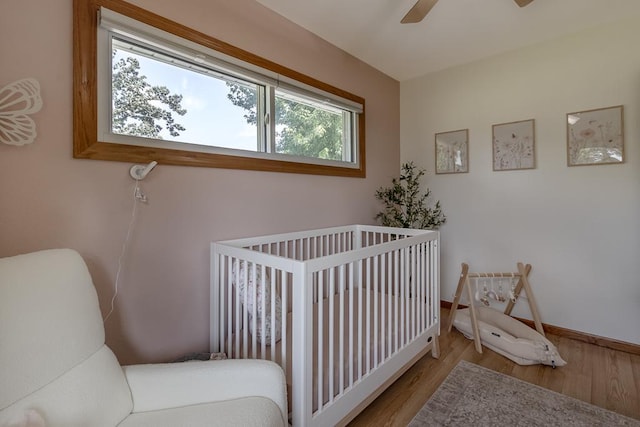 385 Lexington Ave, Le Center, MN 56057 - bedroom with wood finished floors, a nursery area, and a ceiling fan
