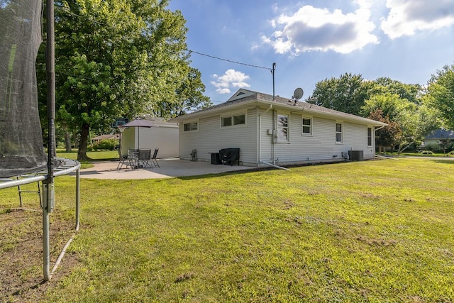 385 Lexington Ave, Le Center, MN 56057 - back of property with a trampoline, a patio, and a lawn