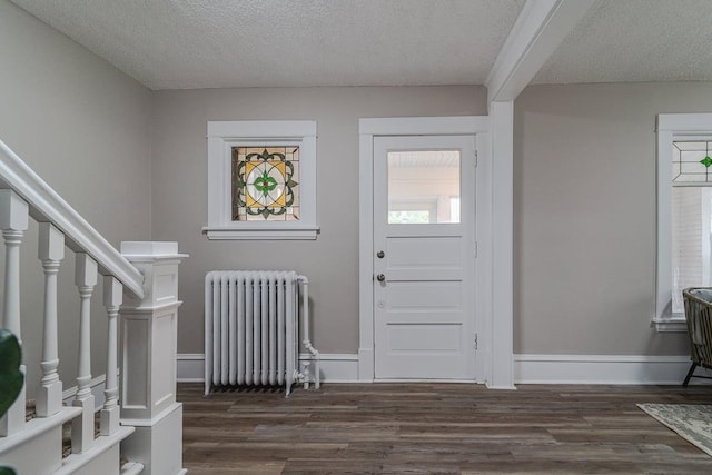 2156 Saint Anthony Ave, Saint Paul, MN 55104 - foyer entrance with radiator, a textured ceiling, dark wood finished floors, and stairs