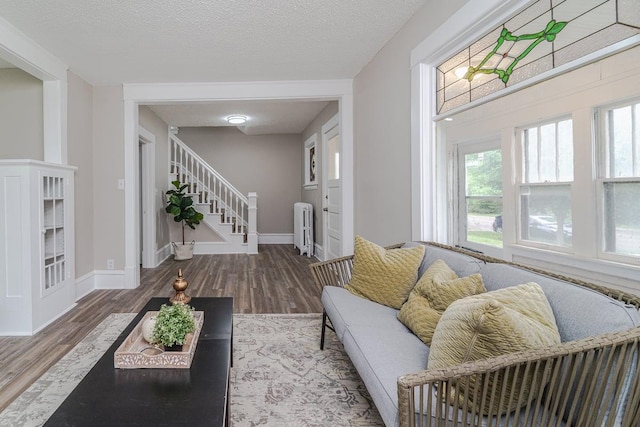 2156 Saint Anthony Ave, Saint Paul, MN 55104 - living room with radiator, wood finished floors, stairs, and a textured ceiling