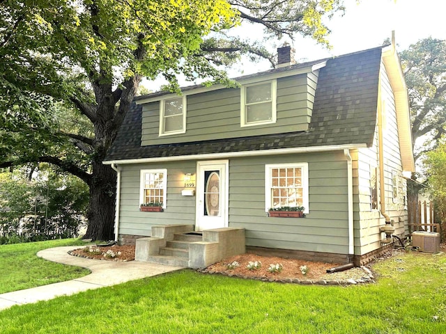 1699 Malvern St, Lauderdale, MN 55113 - view of front of house featuring a chimney, a front yard, a shingled roof, and a gambrel roof