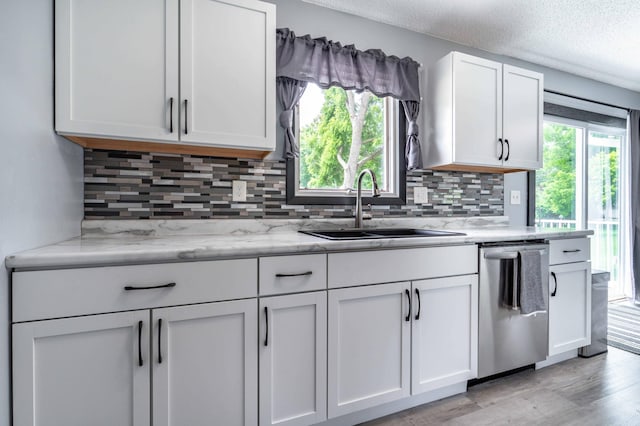 516 Gustavus Ave, Fergus Falls, MN 56537 - kitchen with dishwasher, backsplash, white cabinets, light wood finished floors, and a textured ceiling