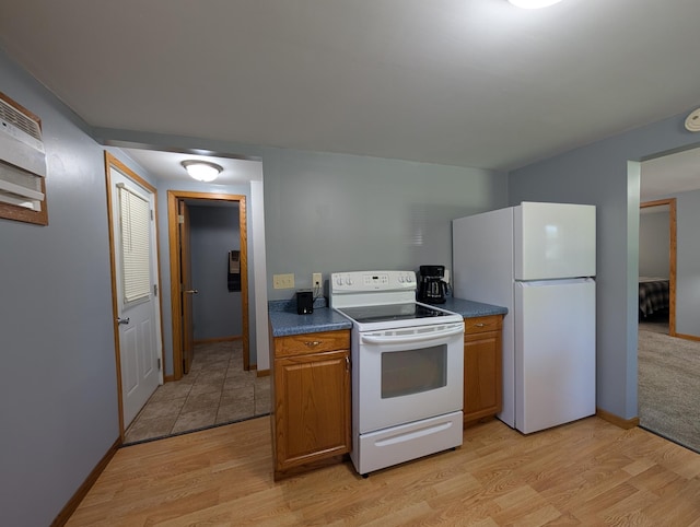 202 Hill St, Russell, MN 56169 - kitchen with white appliances, light wood-style floors, dark countertops, and brown cabinetry