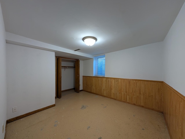 202 Hill St, Russell, MN 56169 - unfurnished bedroom with wooden walls, a closet, and a wainscoted wall