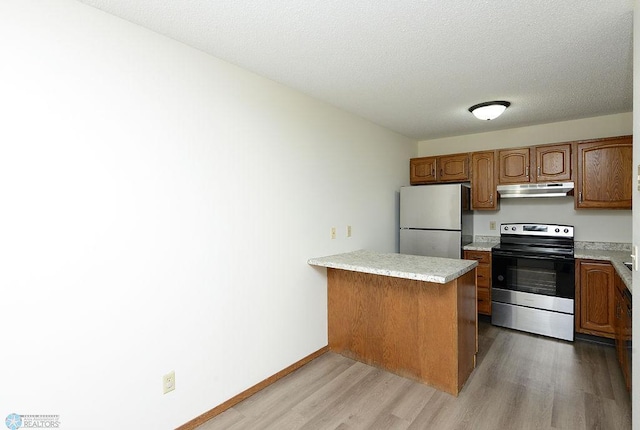 3209 15th Ave S Unit B, Fargo, ND 58103 - kitchen with stainless steel range with electric cooktop, freestanding refrigerator, under cabinet range hood, light wood finished floors, and a peninsula