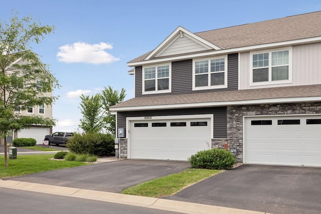 8800 Granite Pass, Woodbury, MN 55129 - view of front facade featuring driveway, a garage, stone siding, and roof with shingles