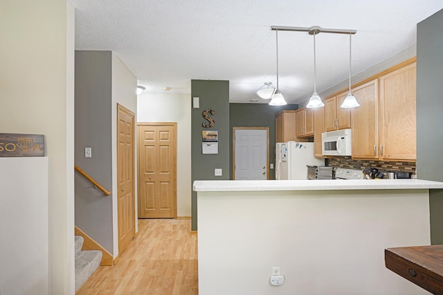 14301 Banyan Ln, Rosemount, MN 55068 - kitchen with white appliances, light wood-style floors, backsplash, hanging light fixtures, and a peninsula