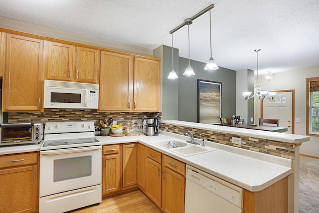 14301 Banyan Ln, Rosemount, MN 55068 - kitchen featuring white appliances, a peninsula, decorative backsplash, light countertops, and a chandelier