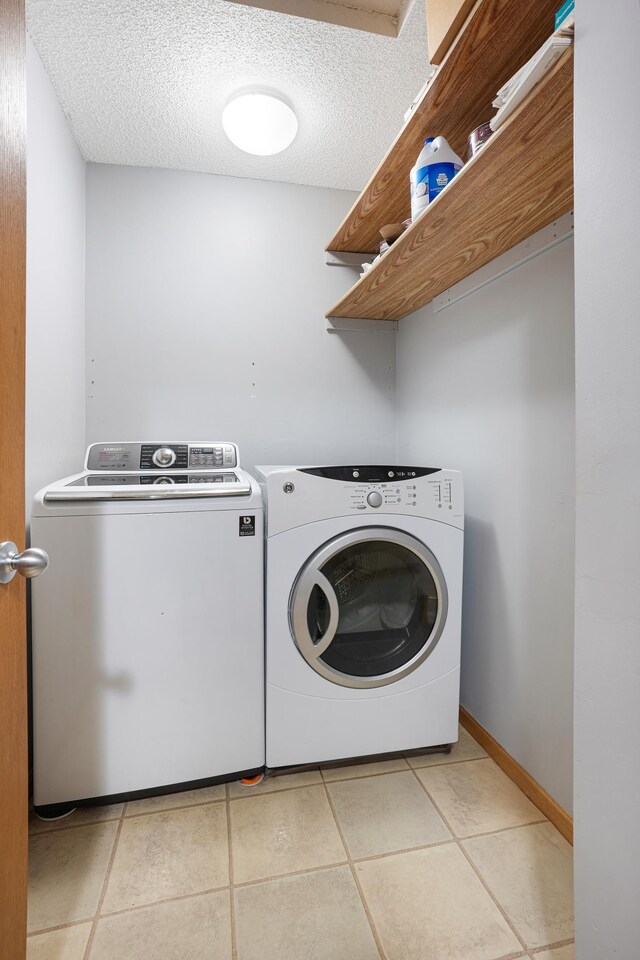 14301 Banyan Ln, Rosemount, MN 55068 - laundry room featuring independent washer and dryer, light tile patterned flooring, and a textured ceiling