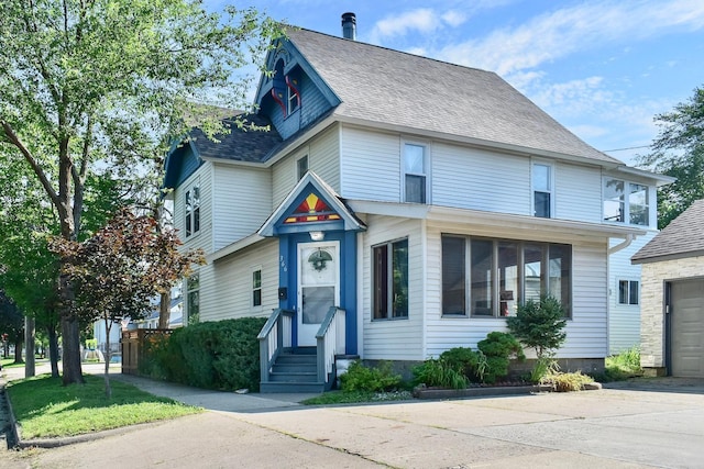 366 Kansas St, Winona, MN 55987 - victorian home with entry steps, roof with shingles, concrete driveway, and a garage