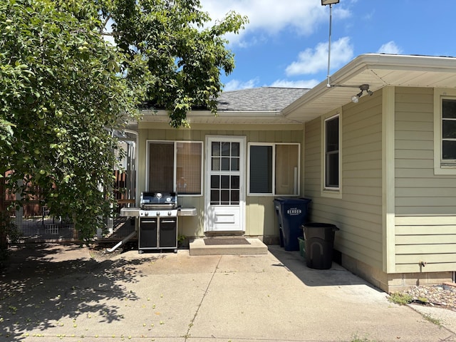 207 Meadow Ln, Benson, MN 56215 - view of exterior entry featuring roof with shingles and a patio area