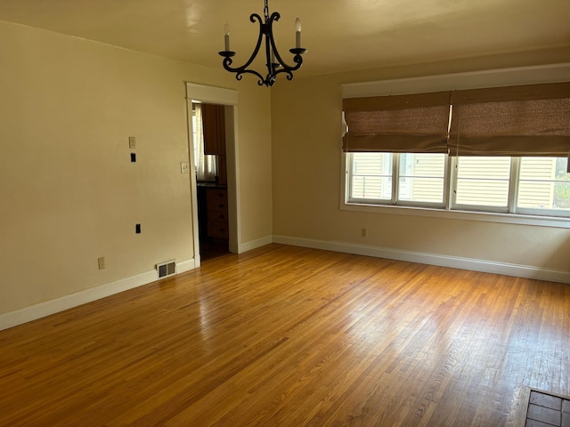 207 Meadow Ln, Benson, MN 56215 - unfurnished room with wood finished floors and a chandelier