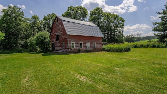 W13263 Hutchinson Rd, Big Bend Twp, WI 54819 - view of property exterior with a barn, a gambrel roof, a yard, and an outdoor structure