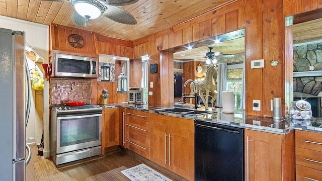 W13263 Hutchinson Rd, Big Bend Twp, WI 54819 - kitchen with appliances with stainless steel finishes, a ceiling fan, brown cabinetry, wooden ceiling, and wood walls