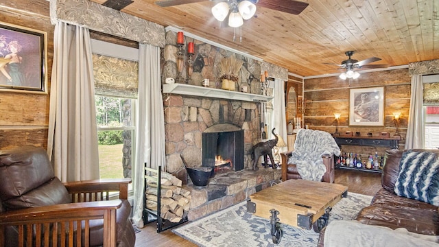 W13263 Hutchinson Rd, Big Bend Twp, WI 54819 - living room with a ceiling fan, hardwood / wood-style floors, wood ceiling, a stone fireplace, and wood walls