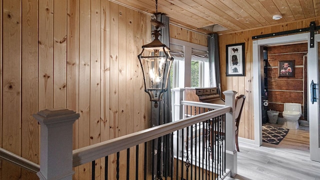 W13263 Hutchinson Rd, Big Bend Twp, WI 54819 - hall with wooden ceiling, wooden walls, wood finished floors, and an upstairs landing