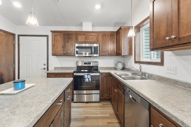 888 Tallgrass Ct, Wanamingo, MN 55983 - kitchen with appliances with stainless steel finishes, light wood finished floors, hanging light fixtures, light countertops, and recessed lighting