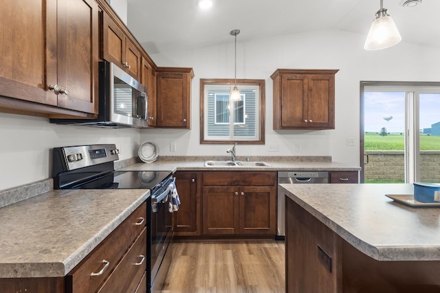888 Tallgrass Ct, Wanamingo, MN 55983 - kitchen with appliances with stainless steel finishes, light wood finished floors, vaulted ceiling, and hanging light fixtures