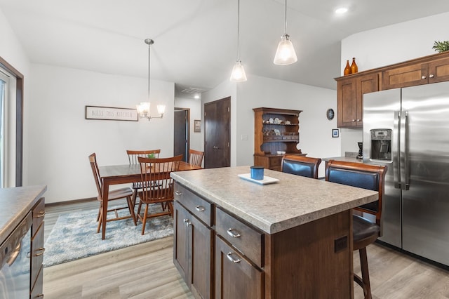 888 Tallgrass Ct, Wanamingo, MN 55983 - kitchen featuring stainless steel appliances, light wood-style flooring, a kitchen island, a breakfast bar, and hanging light fixtures