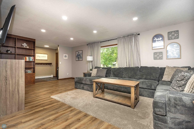 402 5th St NE, Barnesville, MN 56514 - living room featuring a baseboard heating unit, wood finished floors, and recessed lighting