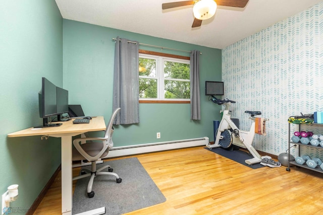402 5th St NE, Barnesville, MN 56514 - office area featuring wood finished floors, ceiling fan, a baseboard radiator, and wallpapered walls