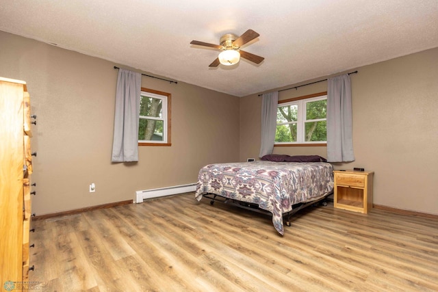 402 5th St NE, Barnesville, MN 56514 - bedroom with a baseboard radiator, light wood finished floors, and ceiling fan
