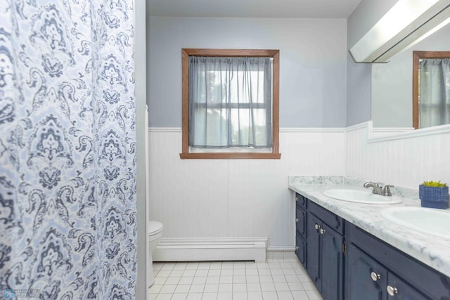 402 5th St NE, Barnesville, MN 56514 - full bathroom with double vanity, a wainscoted wall, tile patterned floors, and a baseboard heating unit