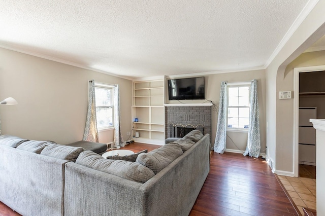 1290 Matilda St, Saint Paul, MN 55117 - living area featuring plenty of natural light, a textured ceiling, a brick fireplace, dark wood-type flooring, and crown molding