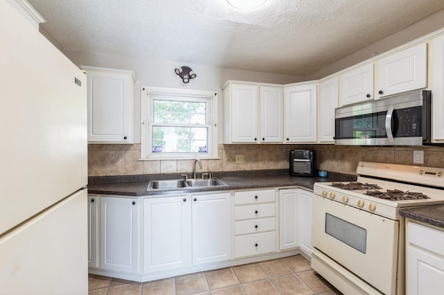 1290 Matilda St, Saint Paul, MN 55117 - kitchen featuring white appliances, dark countertops, backsplash, white cabinets, and a textured ceiling