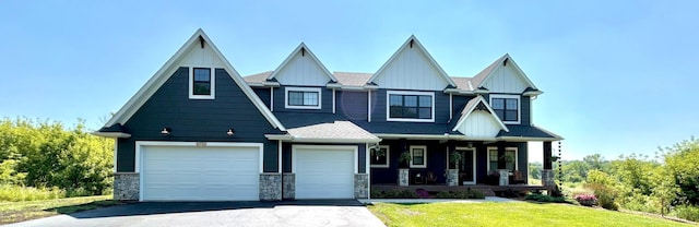 8750 Vernon St, Greenfield, MN 55373 - craftsman inspired home with covered porch, asphalt driveway, board and batten siding, a front lawn, and a garage