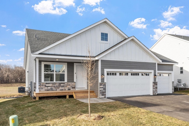 2556 Buffalo Ridge Dr, Buffalo, MN 55313 - view of front of house featuring board and batten siding, stone siding, covered porch, a shingled roof, and driveway