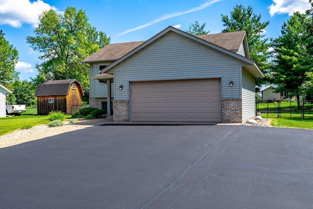 6617 378th St, North Branch, MN 55056 - view of front of house featuring brick siding, a storage shed, a garage, and asphalt driveway