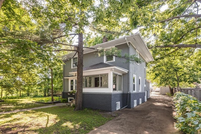 4215 Unity Ave N, Robbinsdale, MN 55422 - view of front of home featuring brick siding, a chimney, stucco siding, and driveway