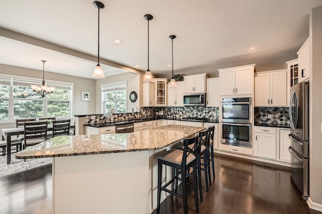1535 138th St E, Rosemount, MN 55068 - kitchen featuring stainless steel appliances, dark wood-style flooring, glass insert cabinets, a chandelier, and recessed lighting
