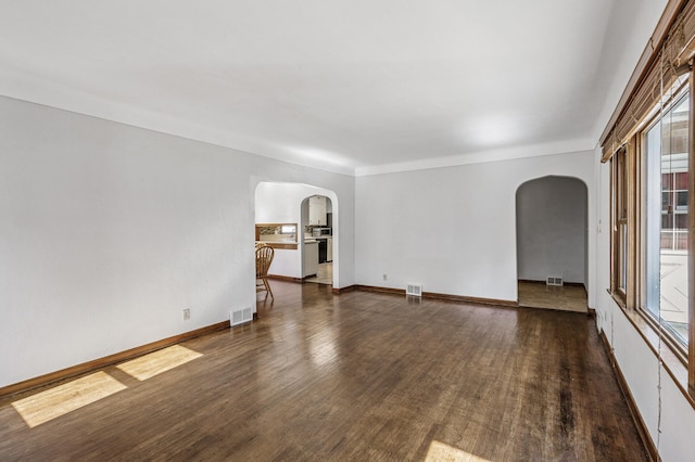 1595 Reaney Ave, Saint Paul, MN 55106 - empty room featuring arched walkways, plenty of natural light, and wood finished floors