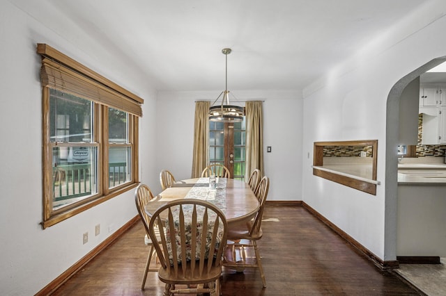 1595 Reaney Ave, Saint Paul, MN 55106 - dining space featuring a chandelier, arched walkways, and dark wood-type flooring
