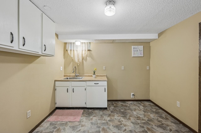 1595 Reaney Ave, Saint Paul, MN 55106 - kitchen with a textured ceiling, white cabinets, stone finish flooring, and light countertops