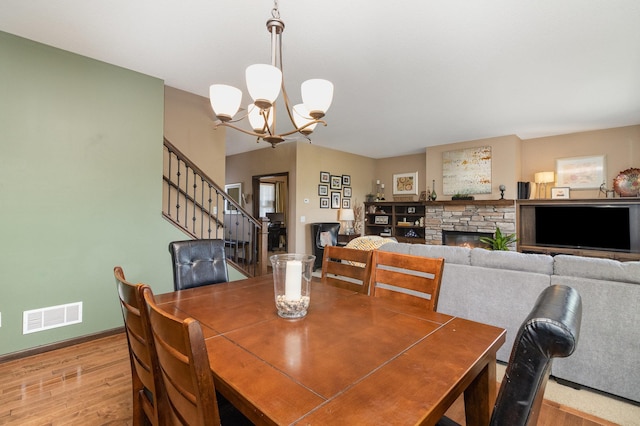 3410 Boulder Trl, Webster, MN 55088 - dining area featuring light wood finished floors, a chandelier, stairway, and a fireplace